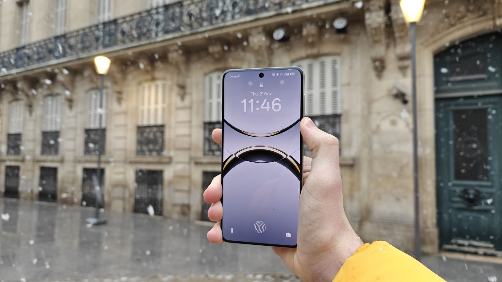 The Oppo Find X8 Pro against some buildings, with the display on and lockscreen visible