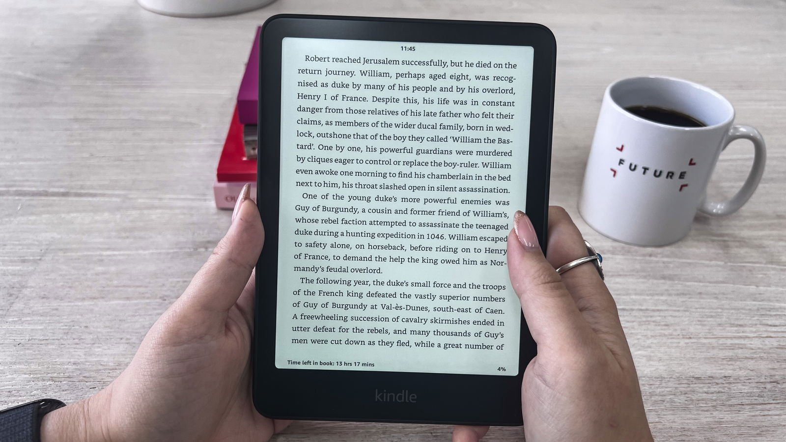 A person reading a page of a book on the Amazon Kindle Paperwhite (2024)